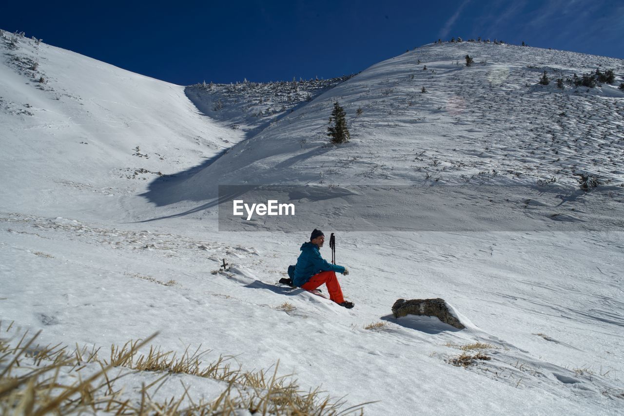 MAN ON SNOWCAPPED MOUNTAIN