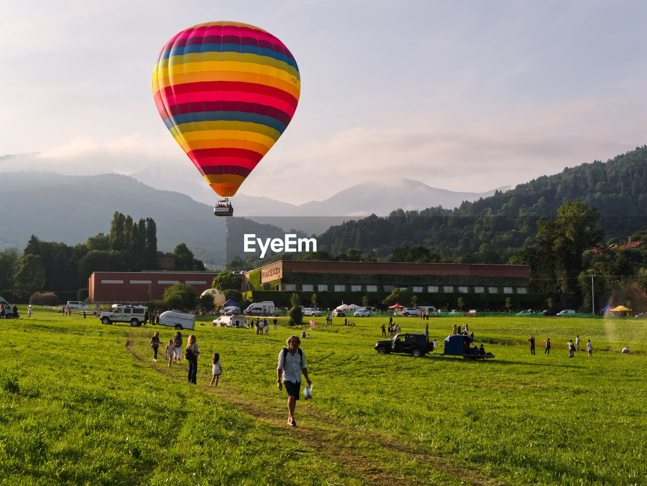 VIEW OF HOT AIR BALLOONS FLYING OVER FIELD