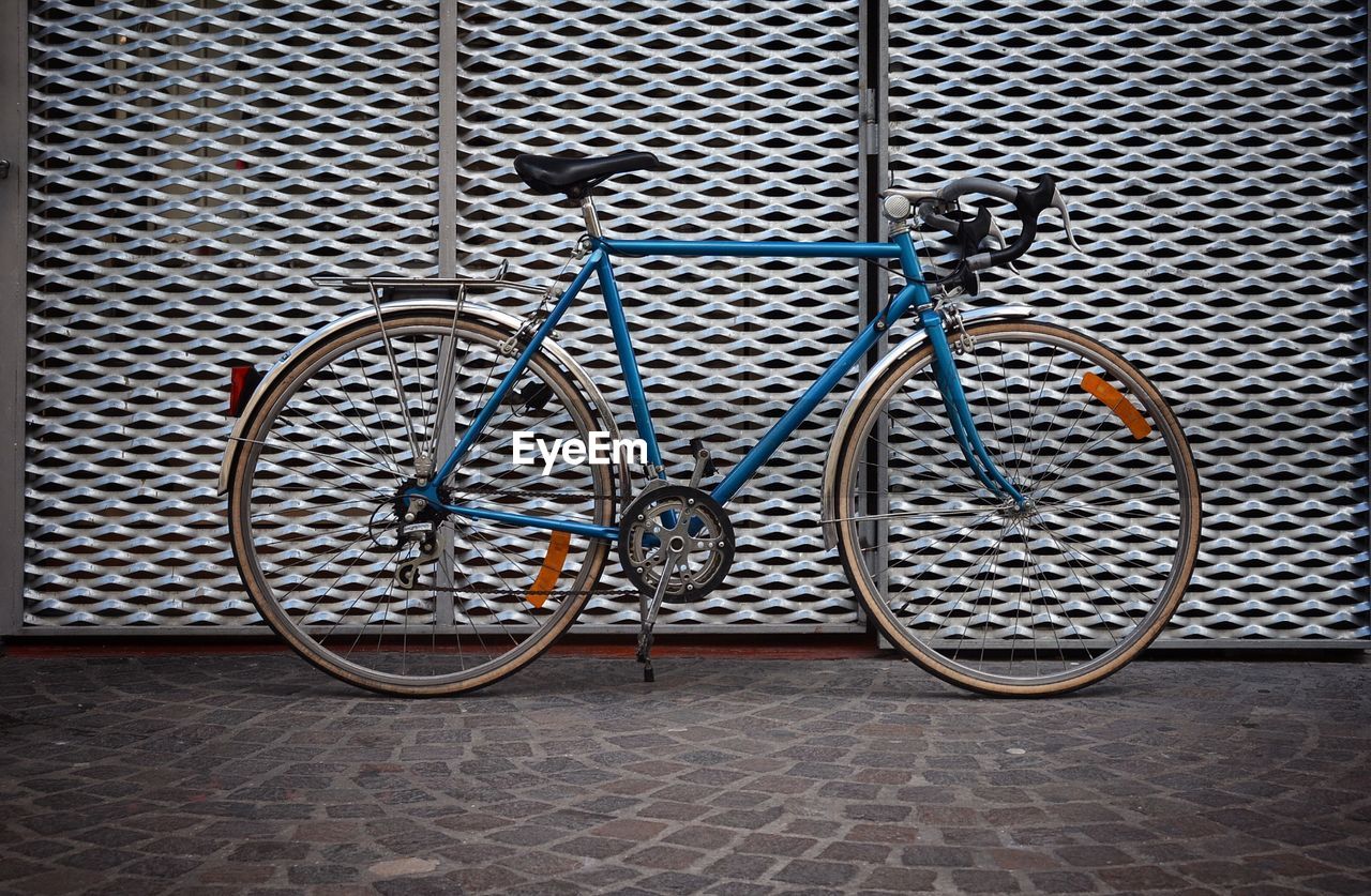 Bicycle parked in front of fence