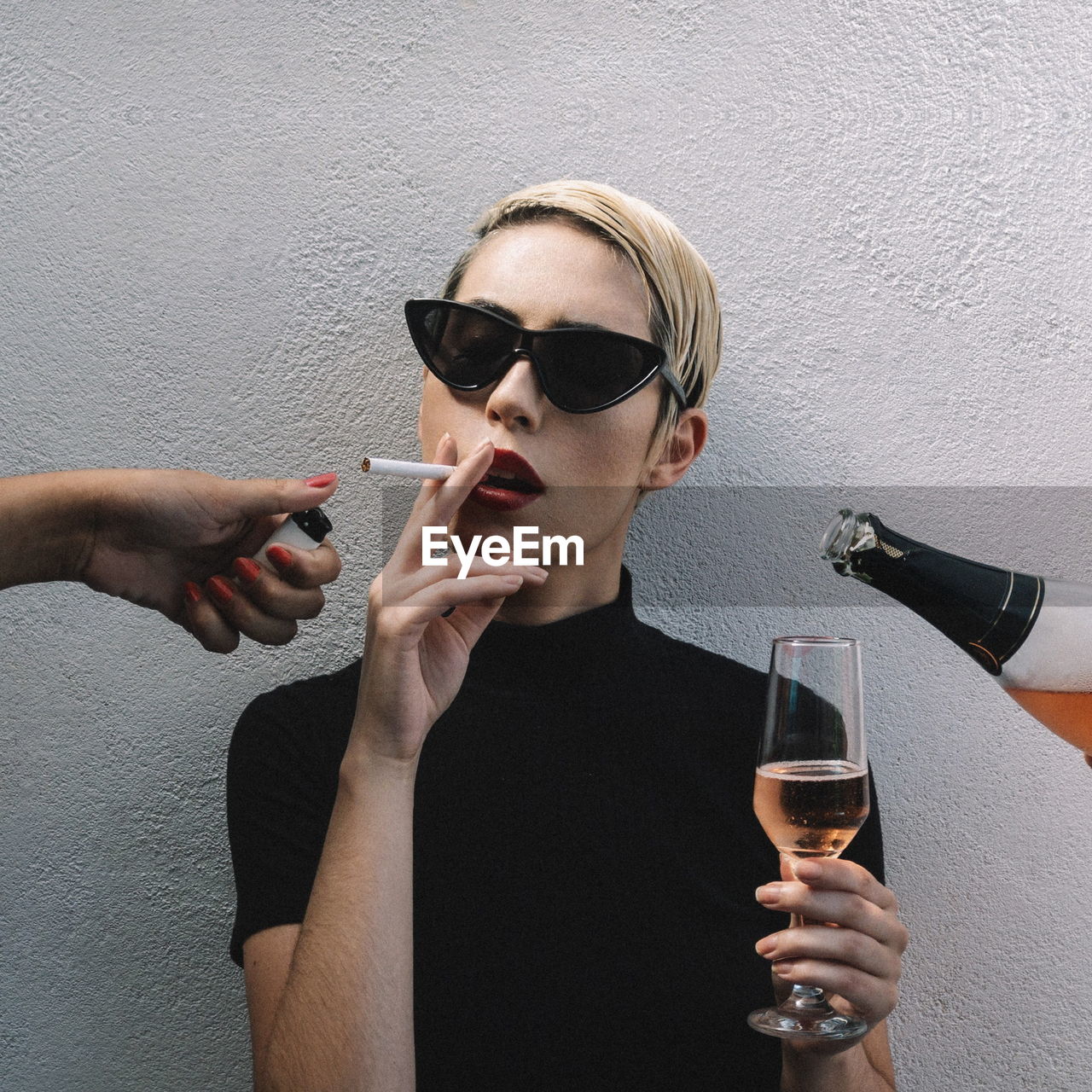 Midsection of woman drinking glass against wall