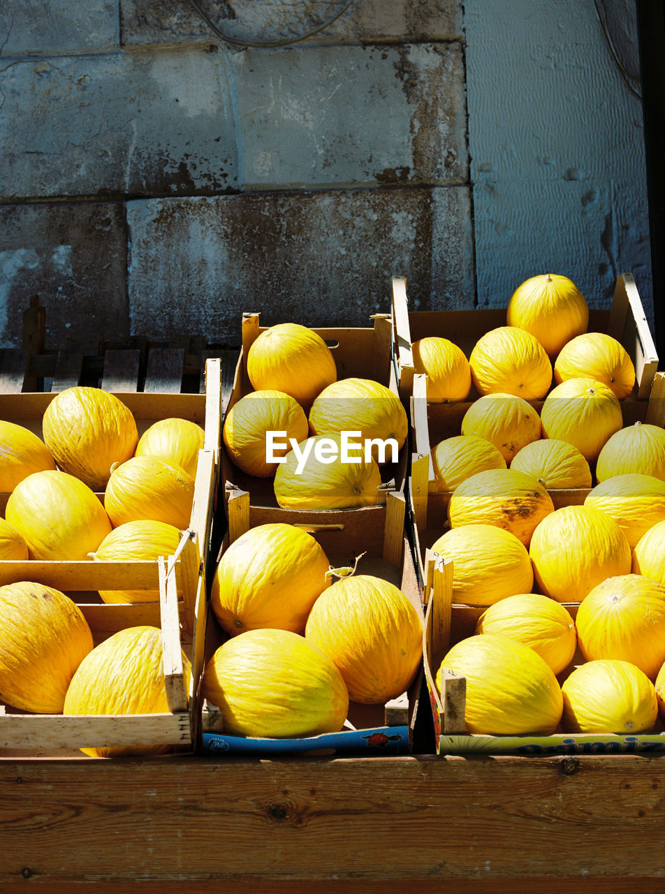 Yellow fruits in containers for sale at market stall