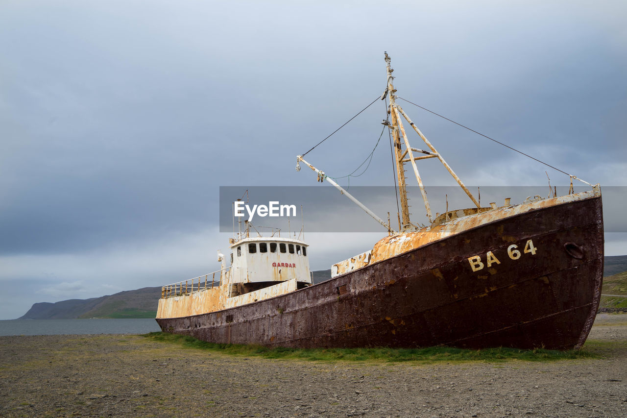 ABANDONED SHIP ON SHORE AGAINST SKY