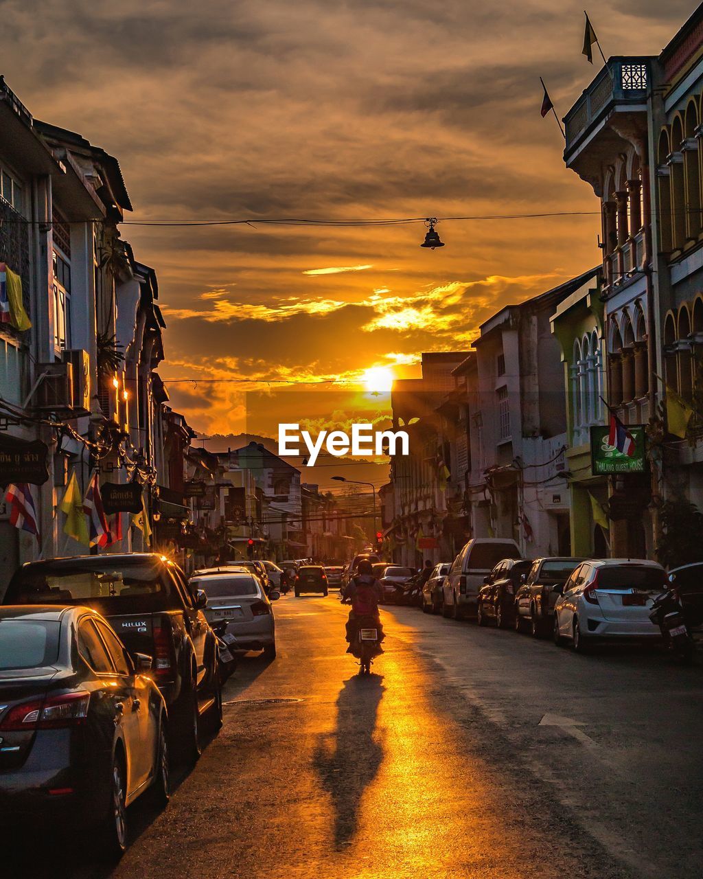 Parked cars on the street of an old town at sunset