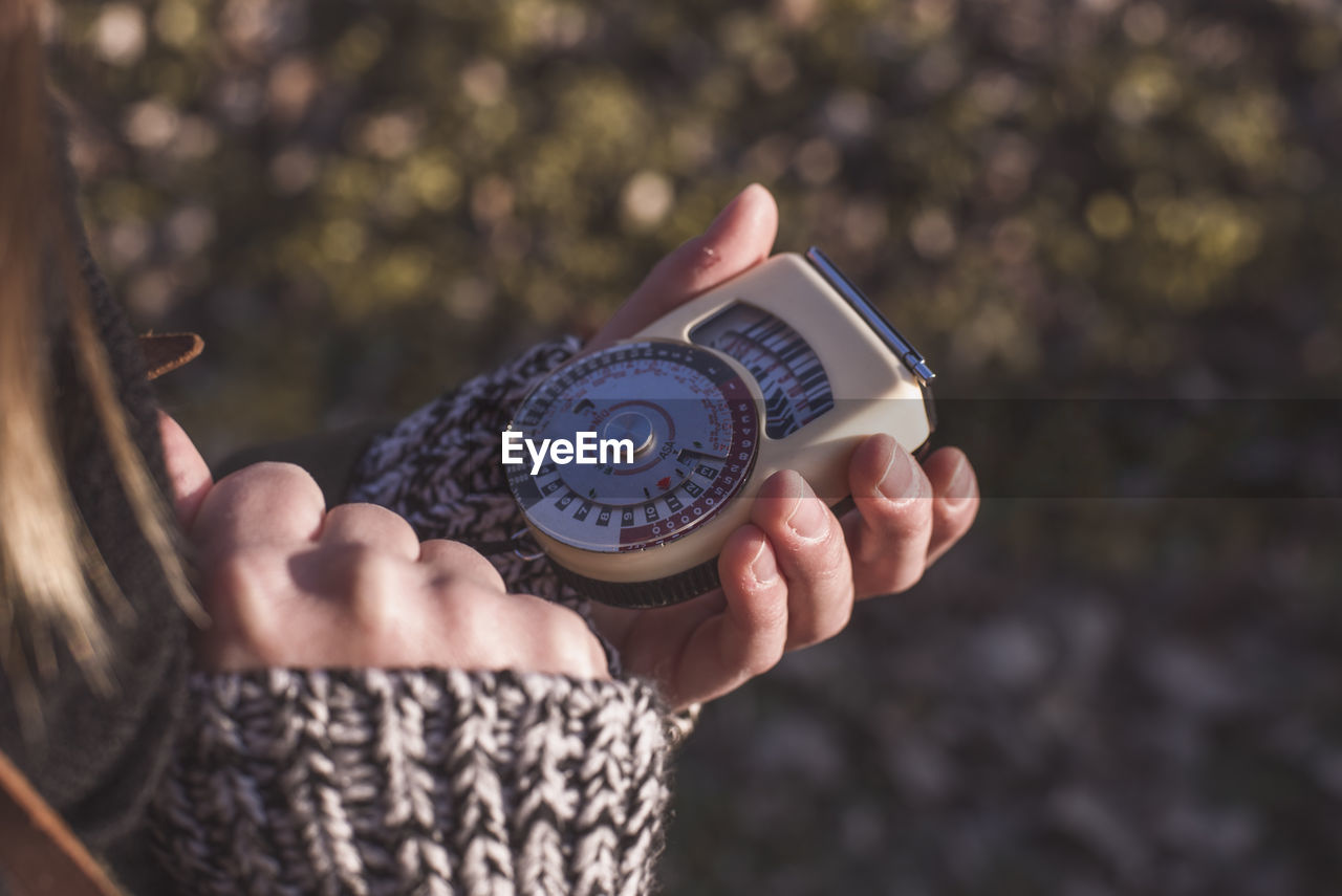 Cropped image of person holding antique navigational compass