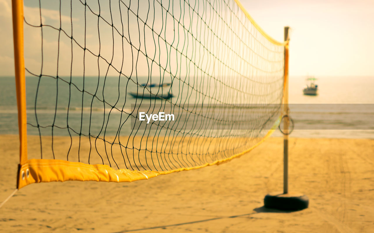 Scenic view of beach volleyball net against sky during sunset