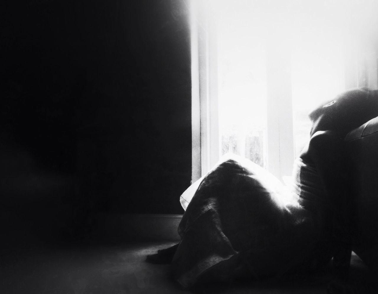 Young woman looking through window