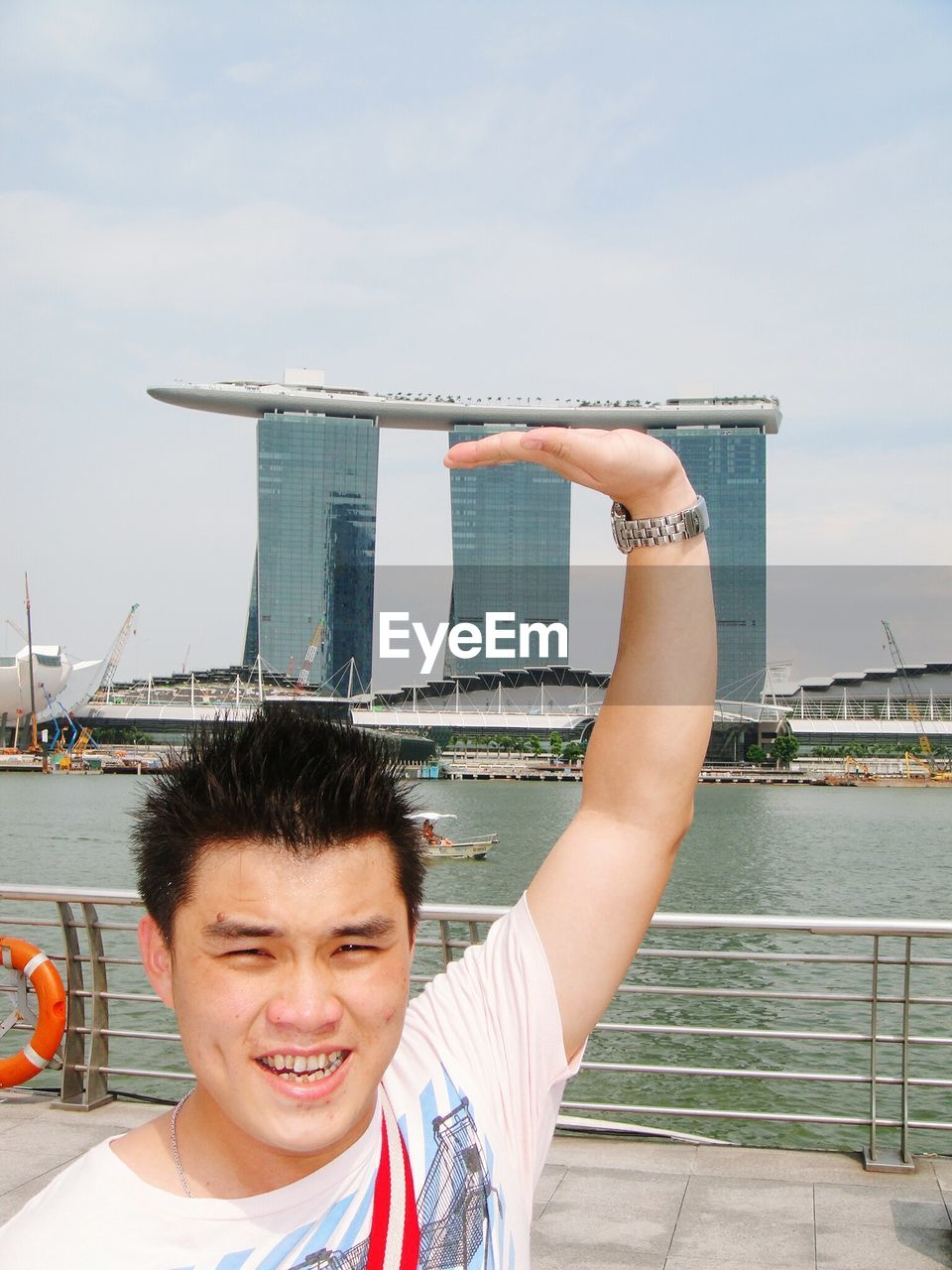 Optical illusion of man touching marina bay sands