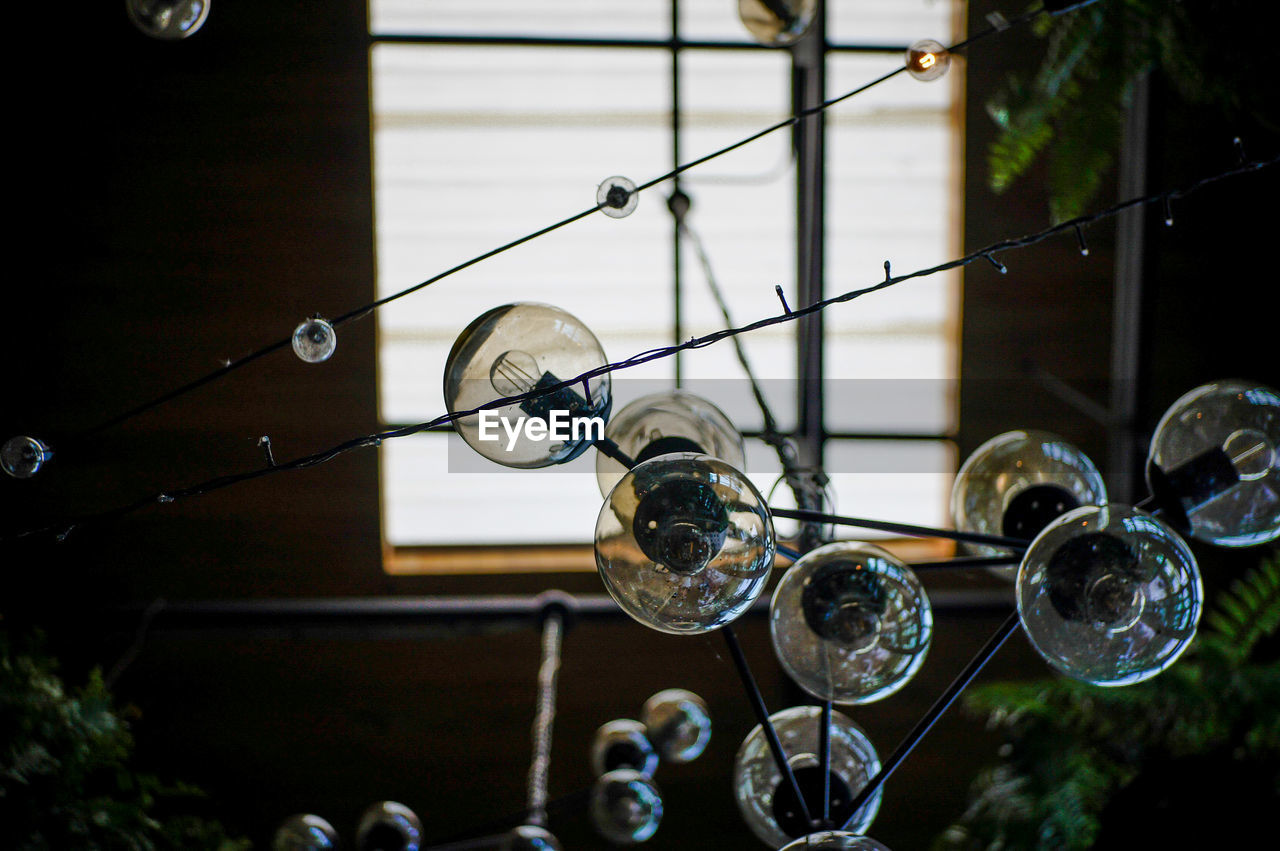 LOW ANGLE VIEW OF BUBBLES HANGING AGAINST WINDOW