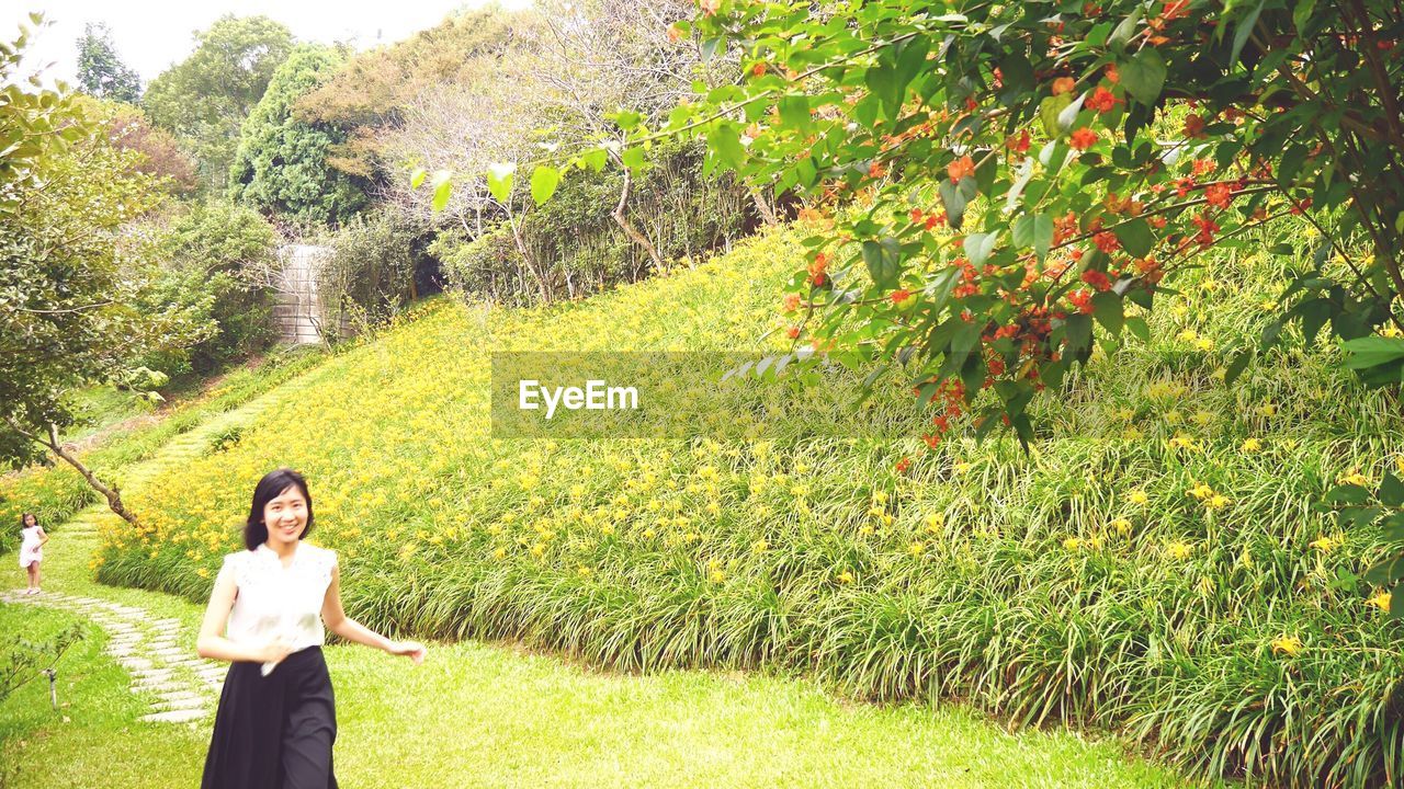 Woman on field against trees