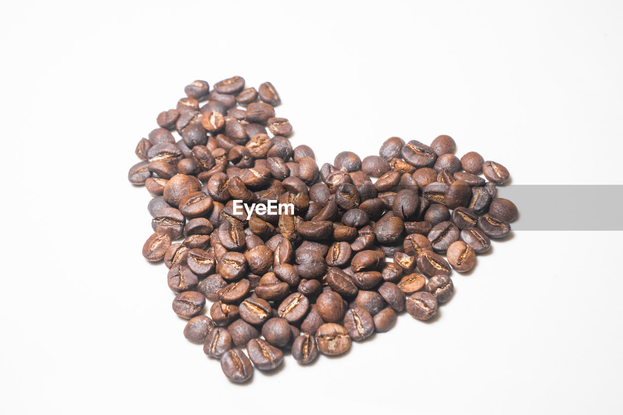 high angle view of roasted coffee beans against white background