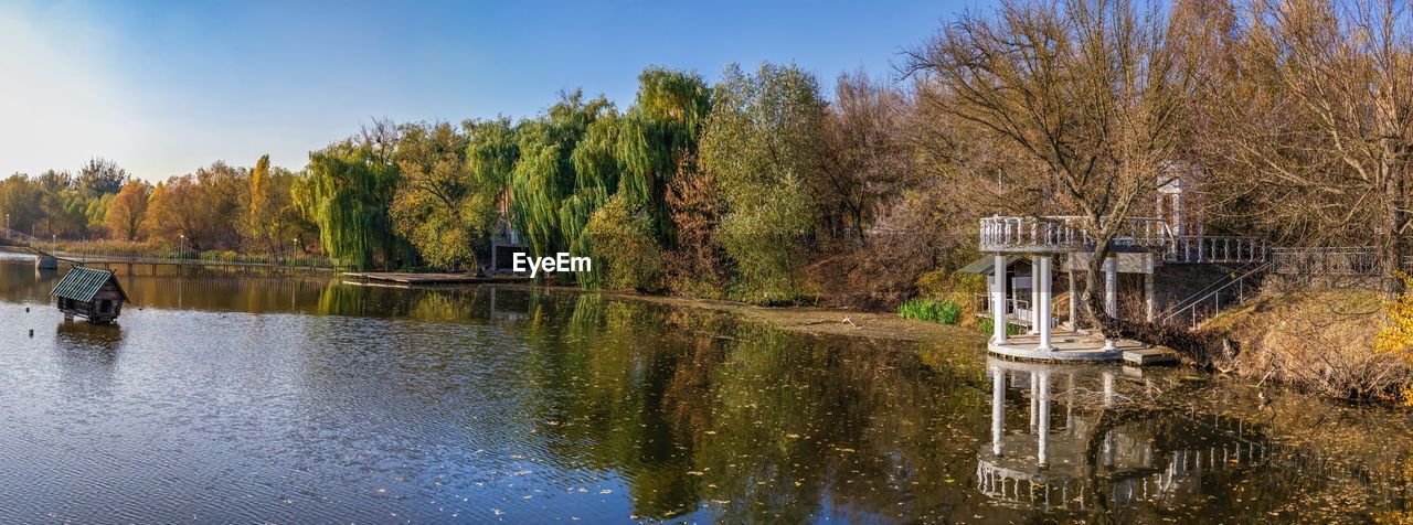 Autumn evening on the blue lake with yellow trees. the ivanki village in cherkasy region, ukraine