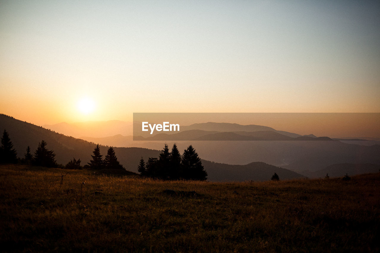SCENIC VIEW OF LANDSCAPE AGAINST CLEAR SKY DURING SUNSET