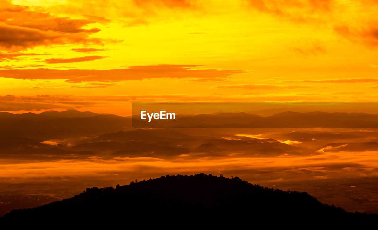 SCENIC VIEW OF SILHOUETTE MOUNTAIN AGAINST ORANGE SKY