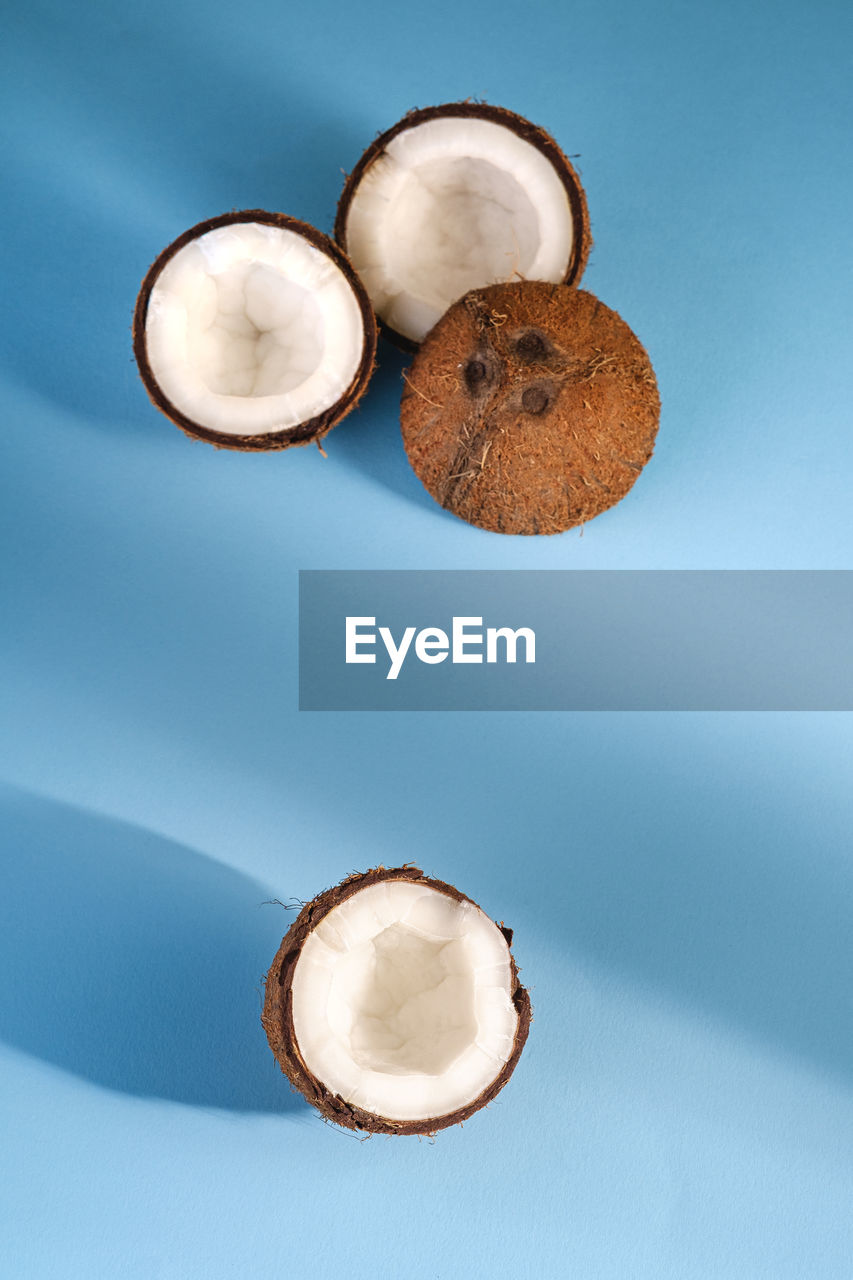 Coconut fruits on blue vibrant plain background, abstract food tropical concept