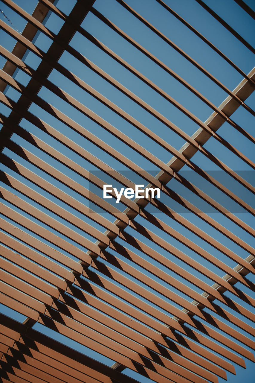 Low angle view of shade structure against clear blue sky