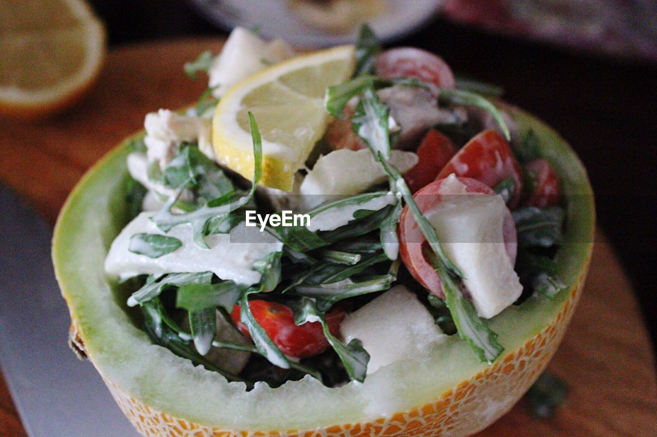 High angle view of salad served in muskmelon at table