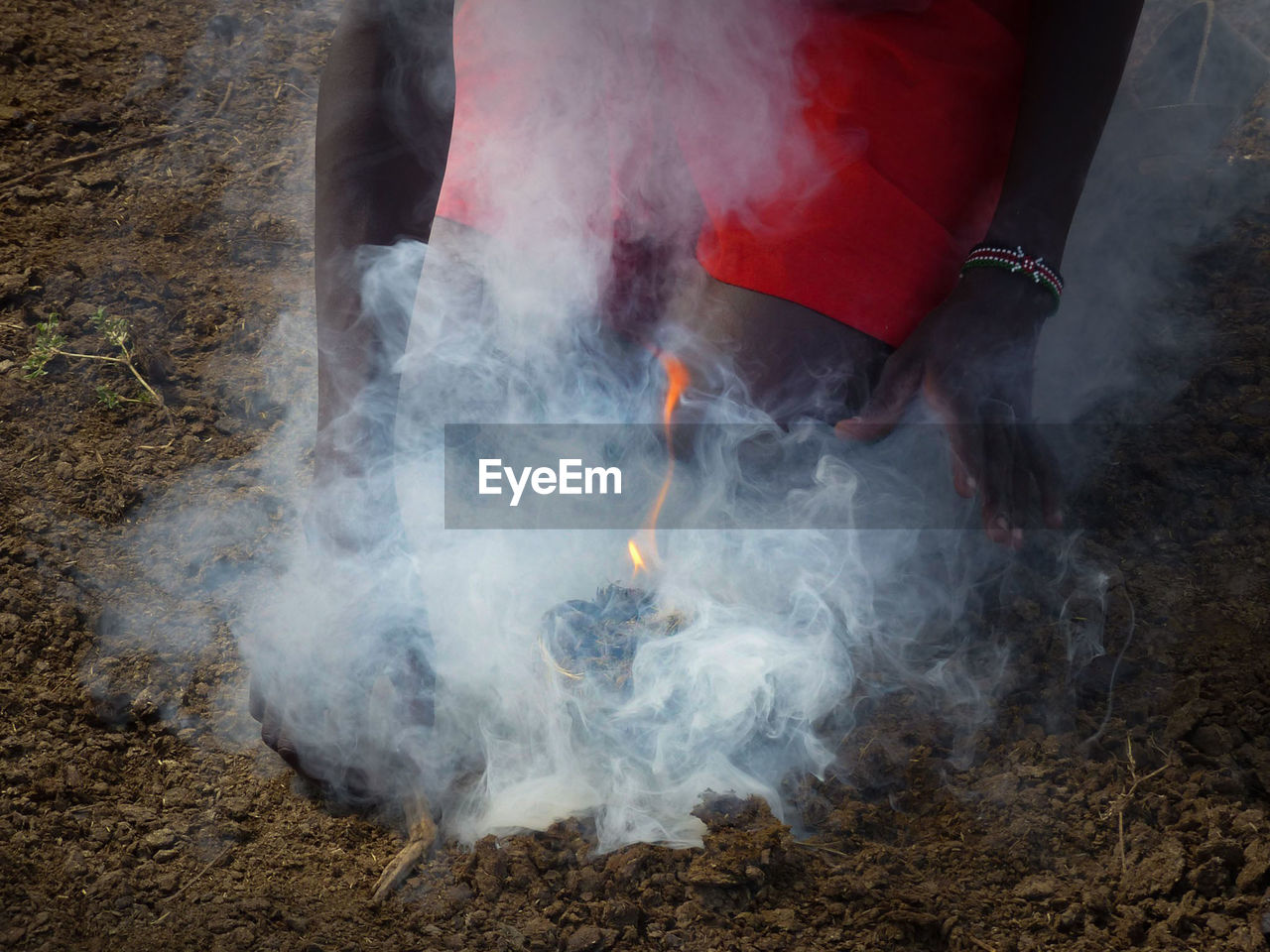 Low section of man standing by smoke on land