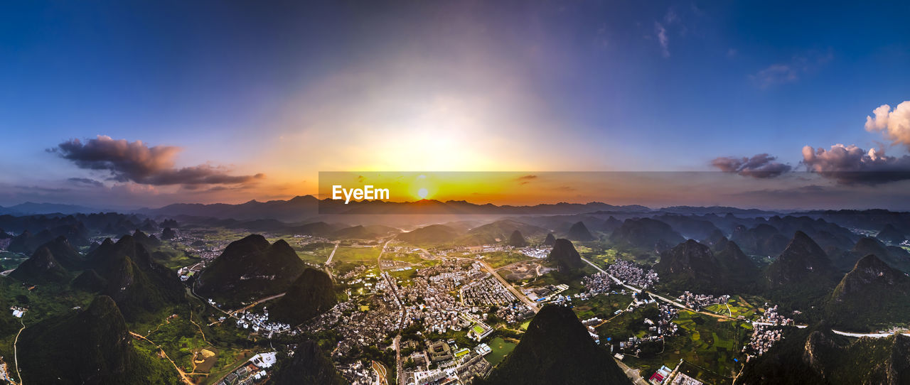 PANORAMIC SHOT OF BUILDINGS AGAINST SKY DURING SUNSET