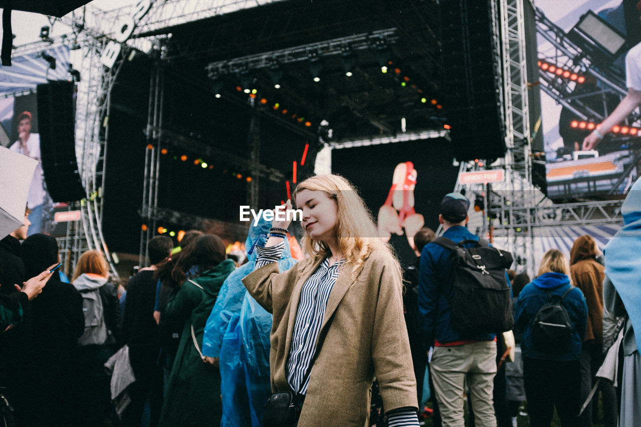 Woman with eyes closed standing at music concert