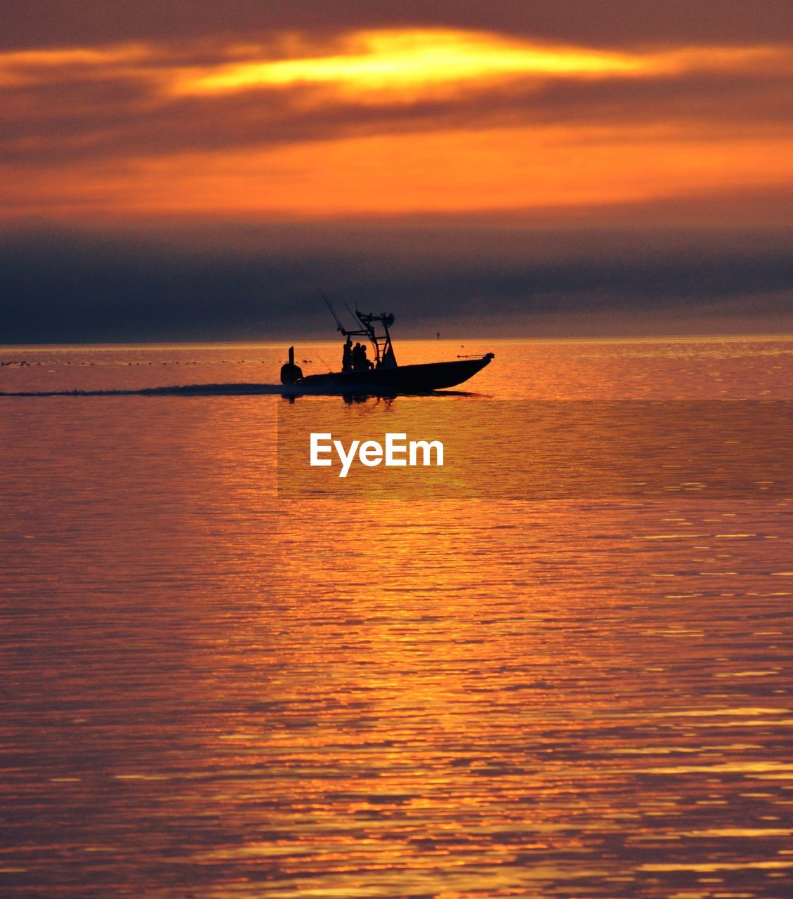 SILHOUETTE MAN ON BOAT AGAINST SEA DURING SUNSET