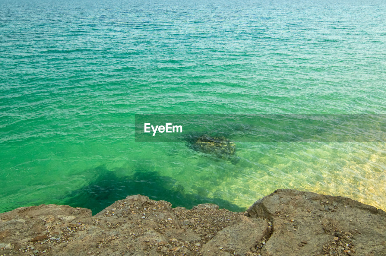 HIGH ANGLE VIEW OF ROCKS IN WATER