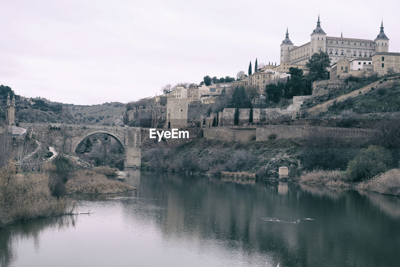 BRIDGE OVER RIVER AGAINST BUILDINGS