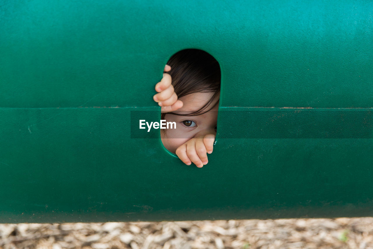 Close-up of portrait of child looking through hole