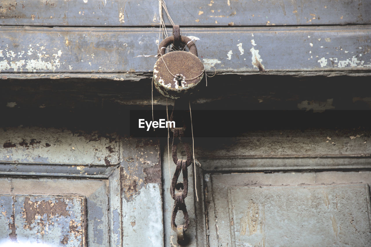 Low angle view of old rusty lock on door