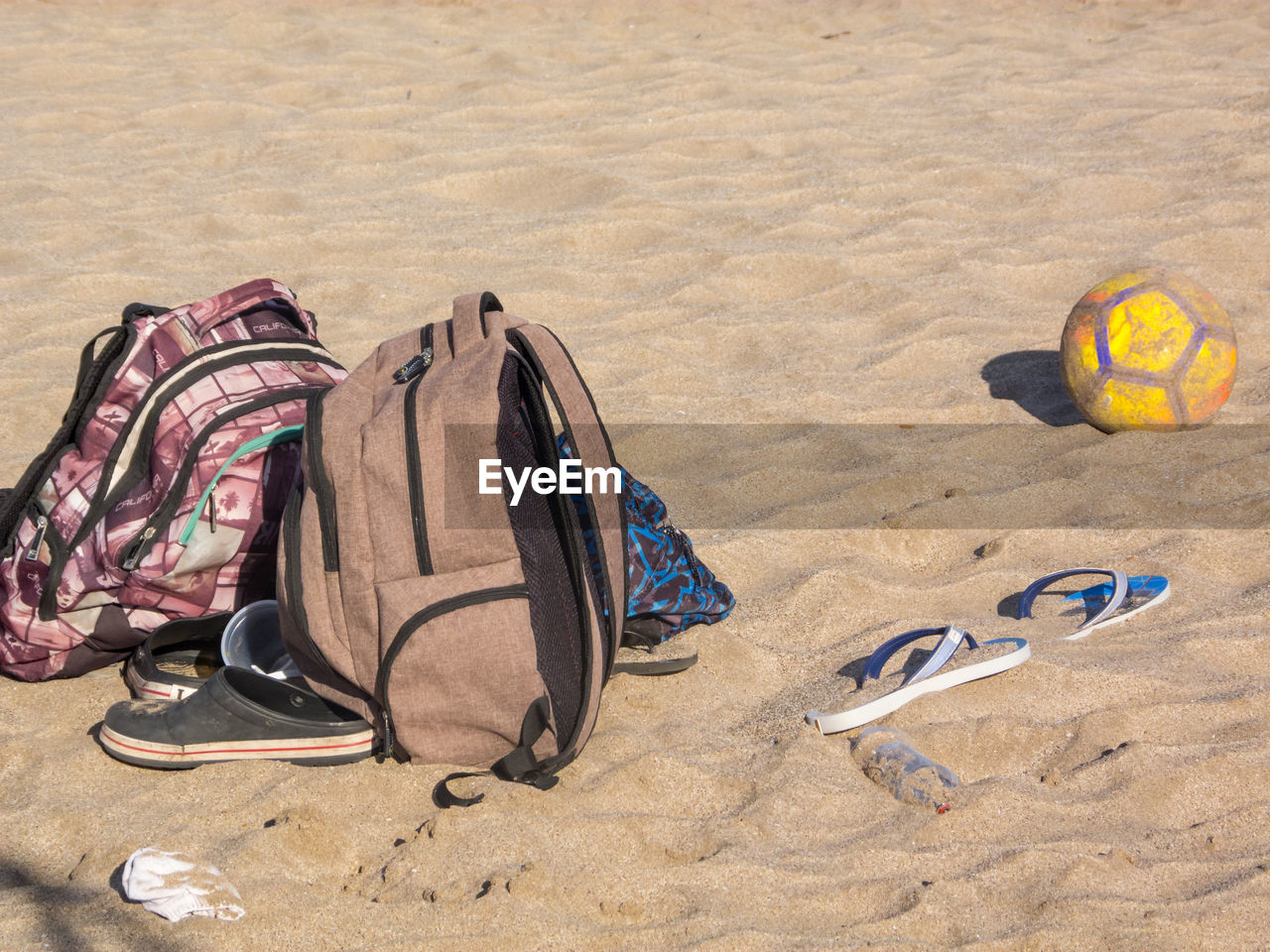 HIGH ANGLE VIEW OF SHOES ON SAND