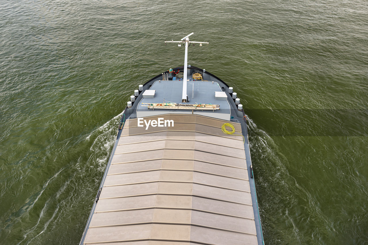 A barge carrying coal with a covered hold on the river rhine. transport of coal and solid fuel.