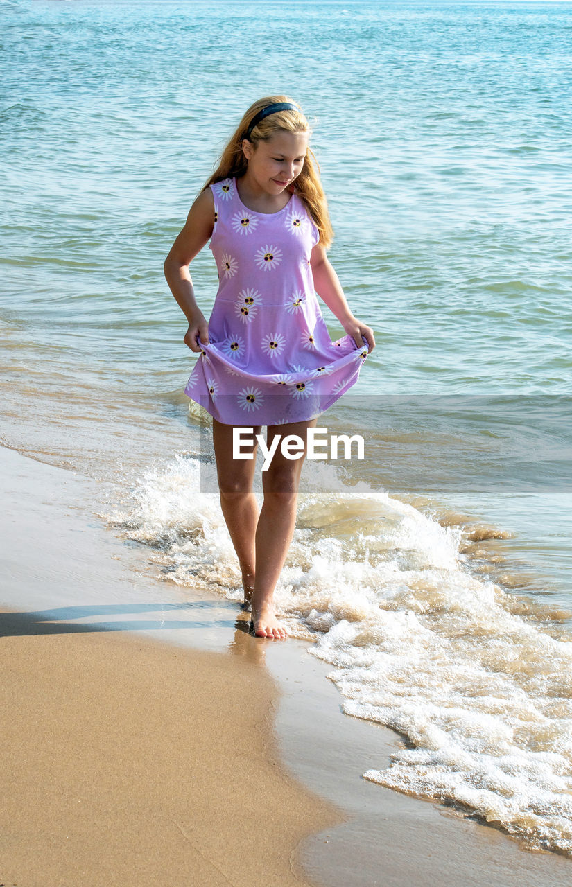 A young girl walks on a pretty beach in michigan usa