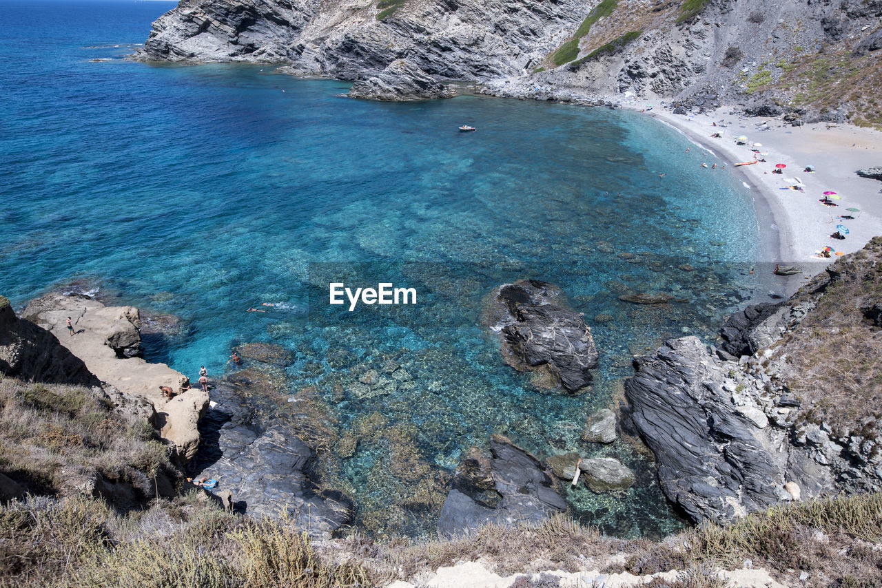 HIGH ANGLE VIEW OF ROCKS ON SEA