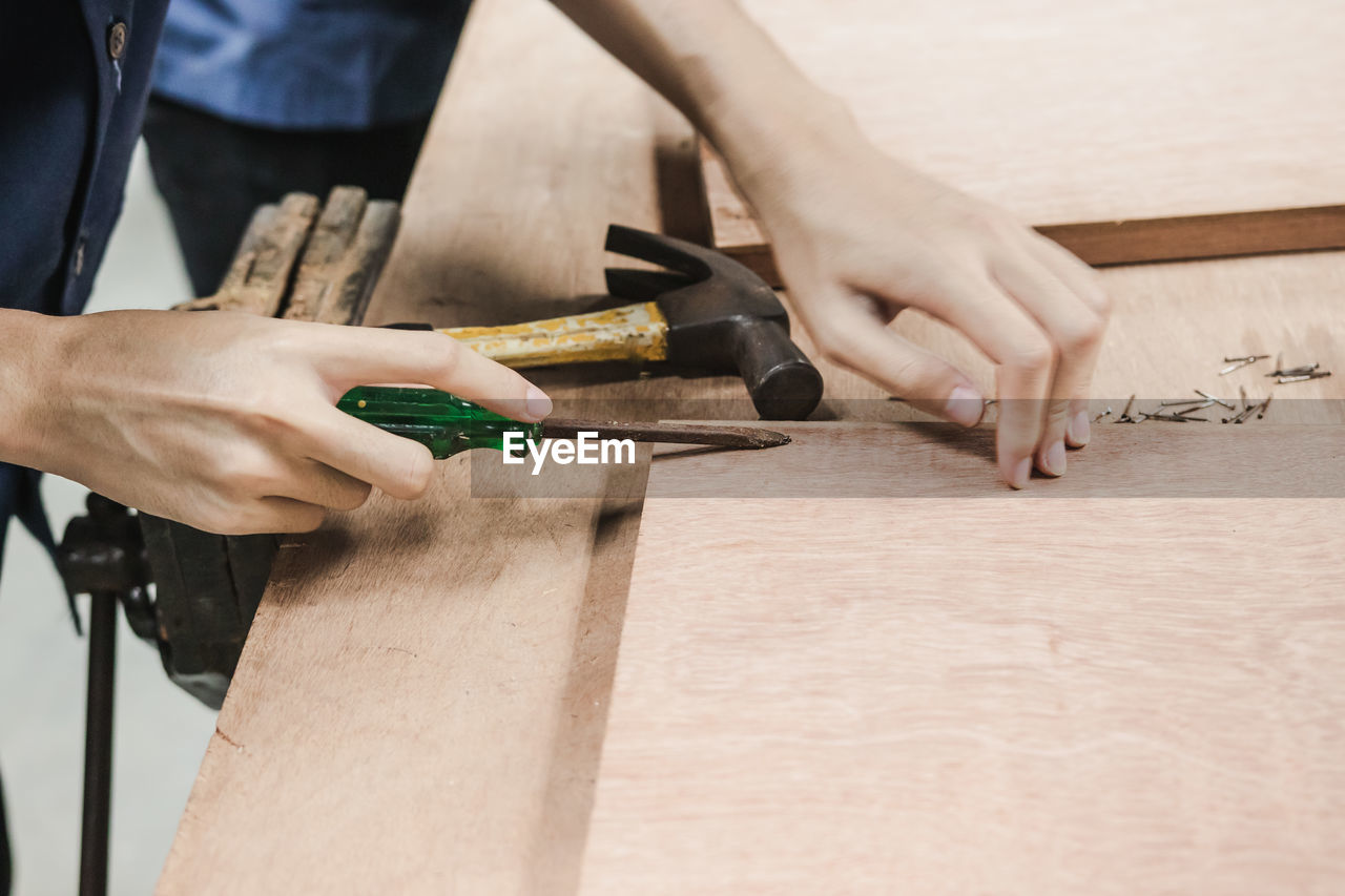 Cropped image of carpenter making furniture in carpentry workshop