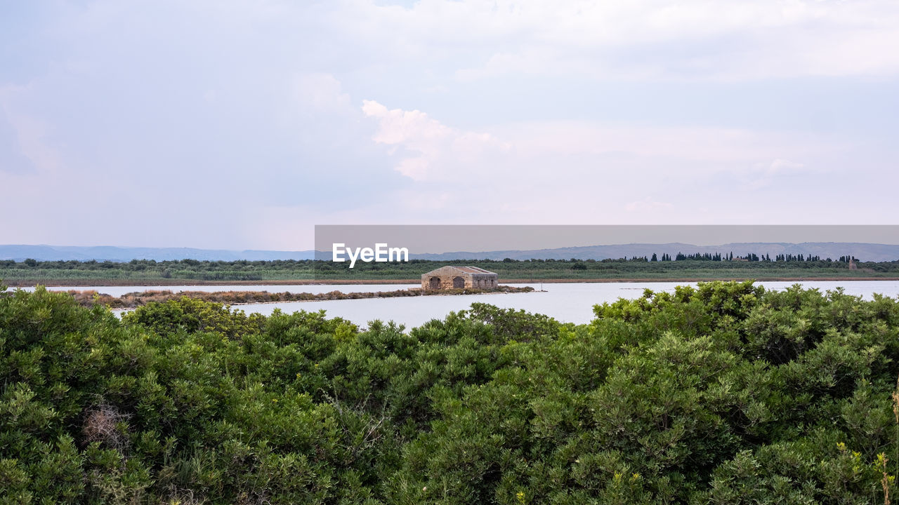 water, sky, plant, sea, tree, nature, coast, land, horizon, shore, cloud, scenics - nature, beauty in nature, environment, no people, architecture, tranquility, reservoir, travel, travel destinations, day, beach, landscape, natural environment, tranquil scene, outdoors, tourism, built structure, bay, growth, ocean, non-urban scene, hill, green, transportation, body of water, building