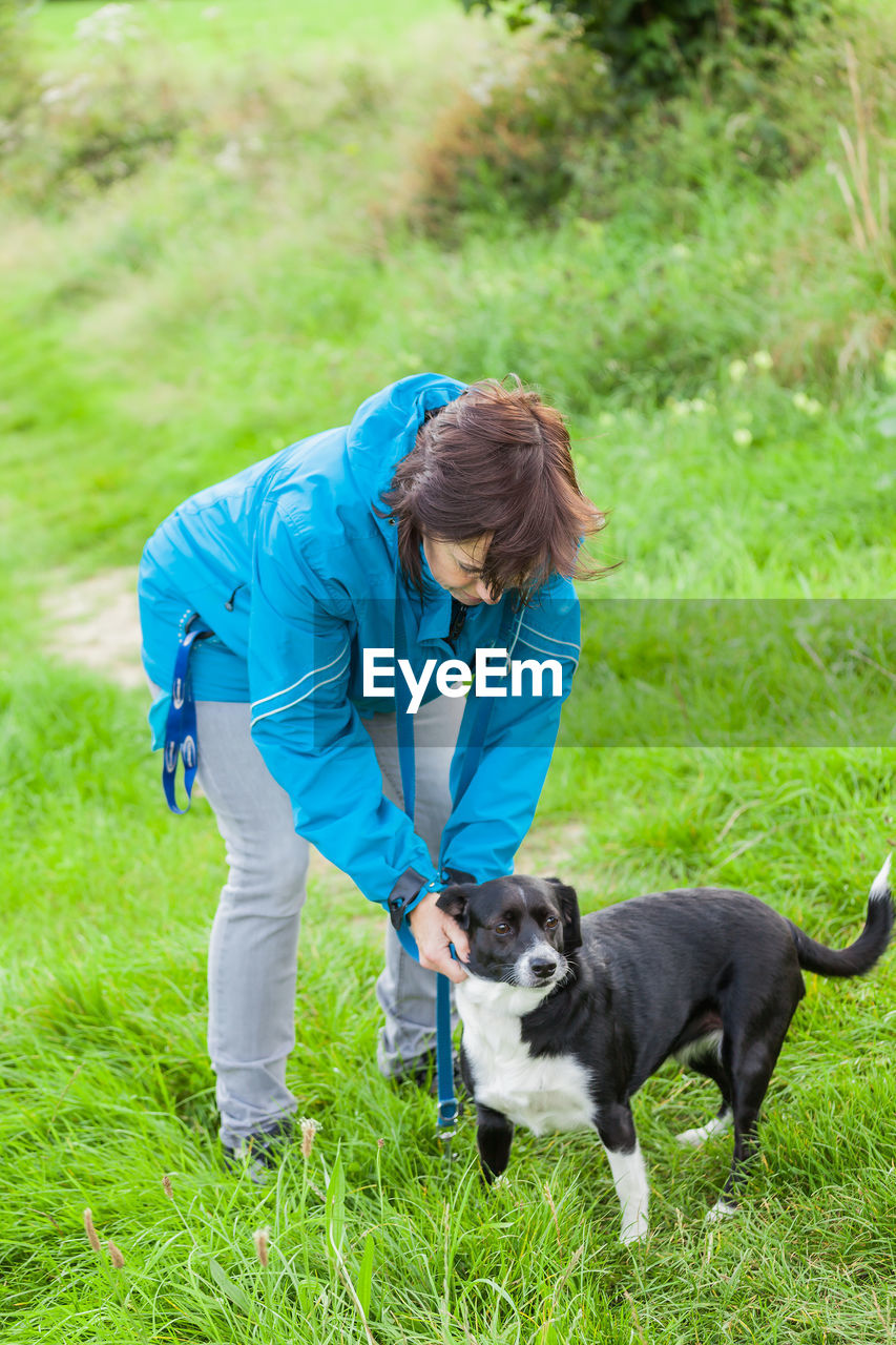 Woman standing with dog on land