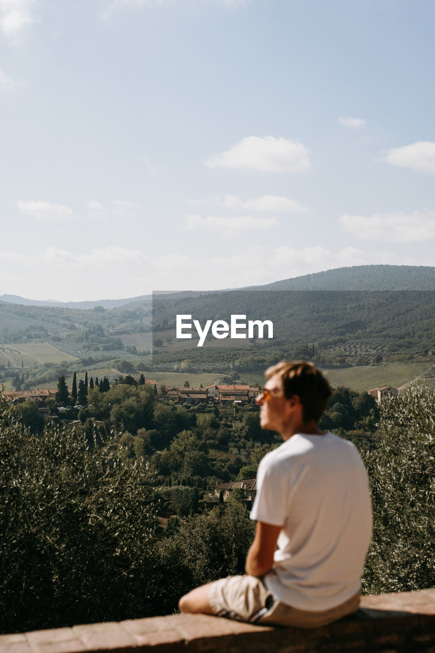 side view of woman sitting on mountain