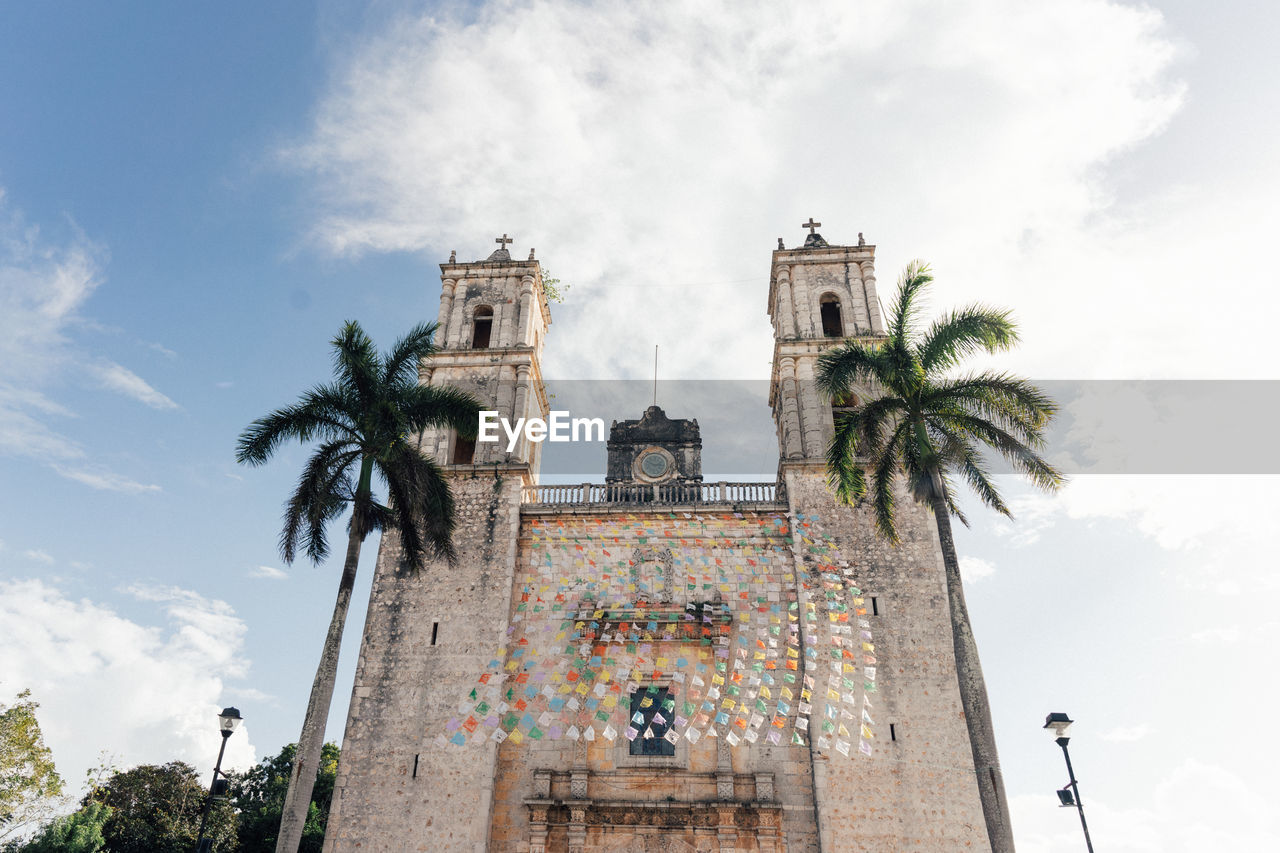 palm tree, tropical climate, sky, architecture, tree, cloud, built structure, travel destinations, building exterior, landmark, nature, plant, low angle view, travel, history, religion, the past, building, tourism, vacation, place of worship, belief, outdoors, day, tower, city, spirituality, no people, date palm tree, holiday