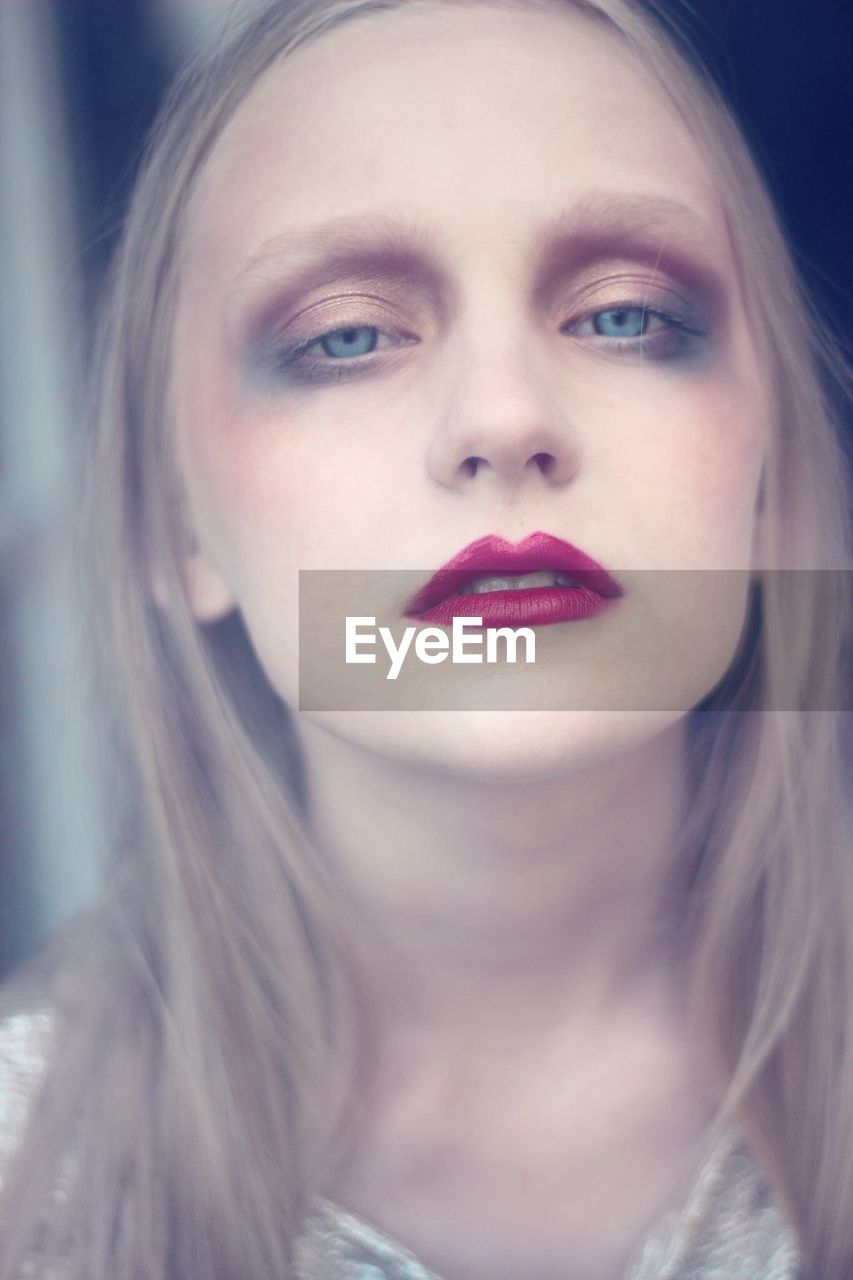 Close-up portrait of teenage girl with make-up at home