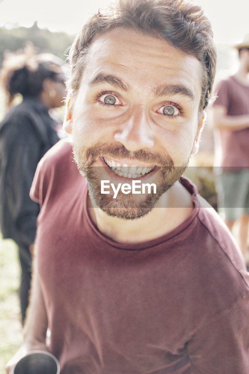 CLOSE-UP PORTRAIT OF SMILING MAN OUTDOORS