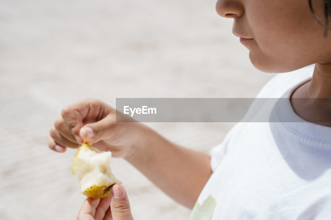 Midsection of girl eating fruit