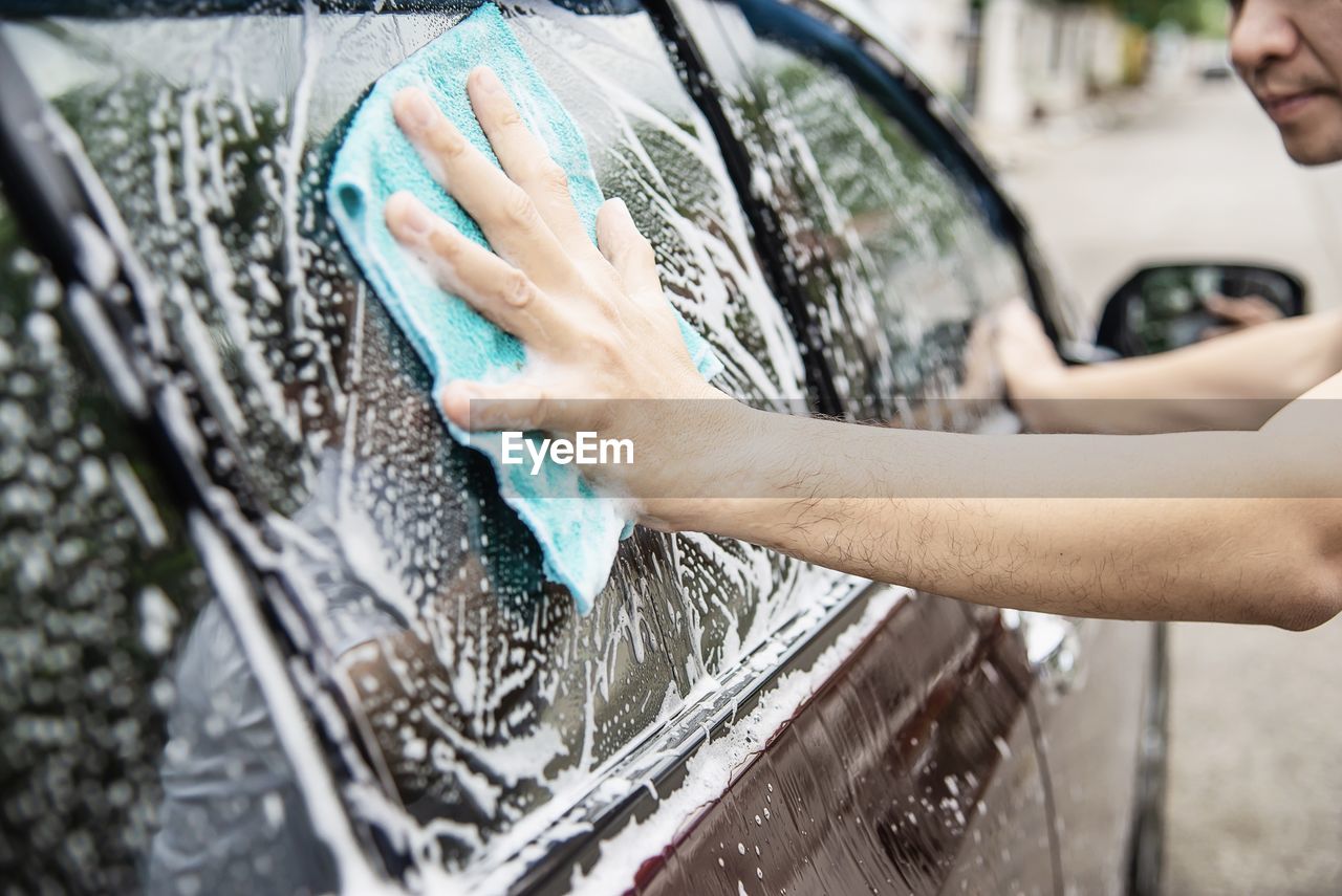 Close-up of man washing car