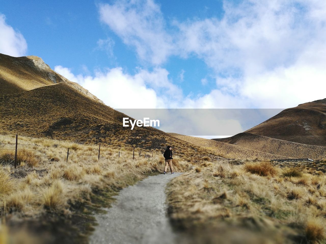 MAN WALKING ON MOUNTAIN ROAD