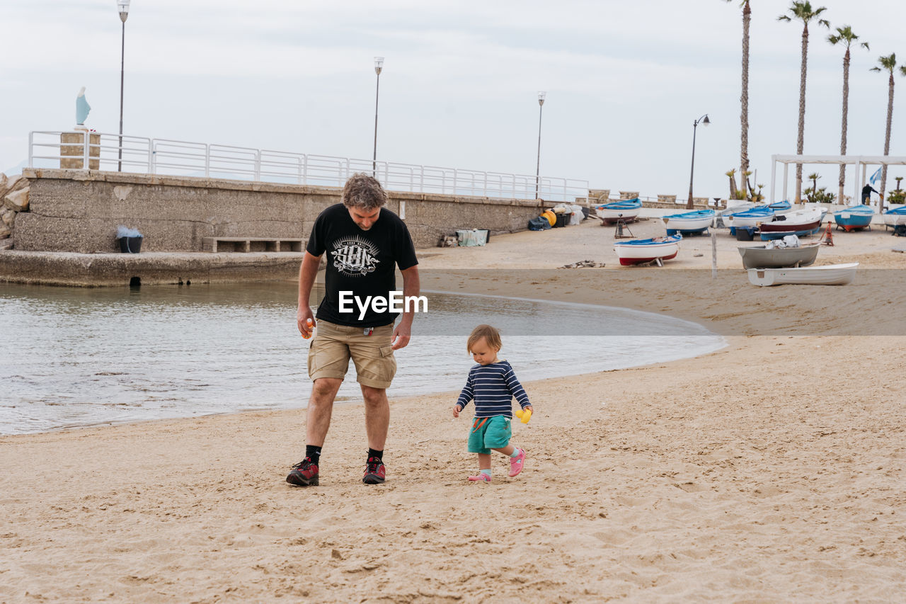 Father and child walking along the beach