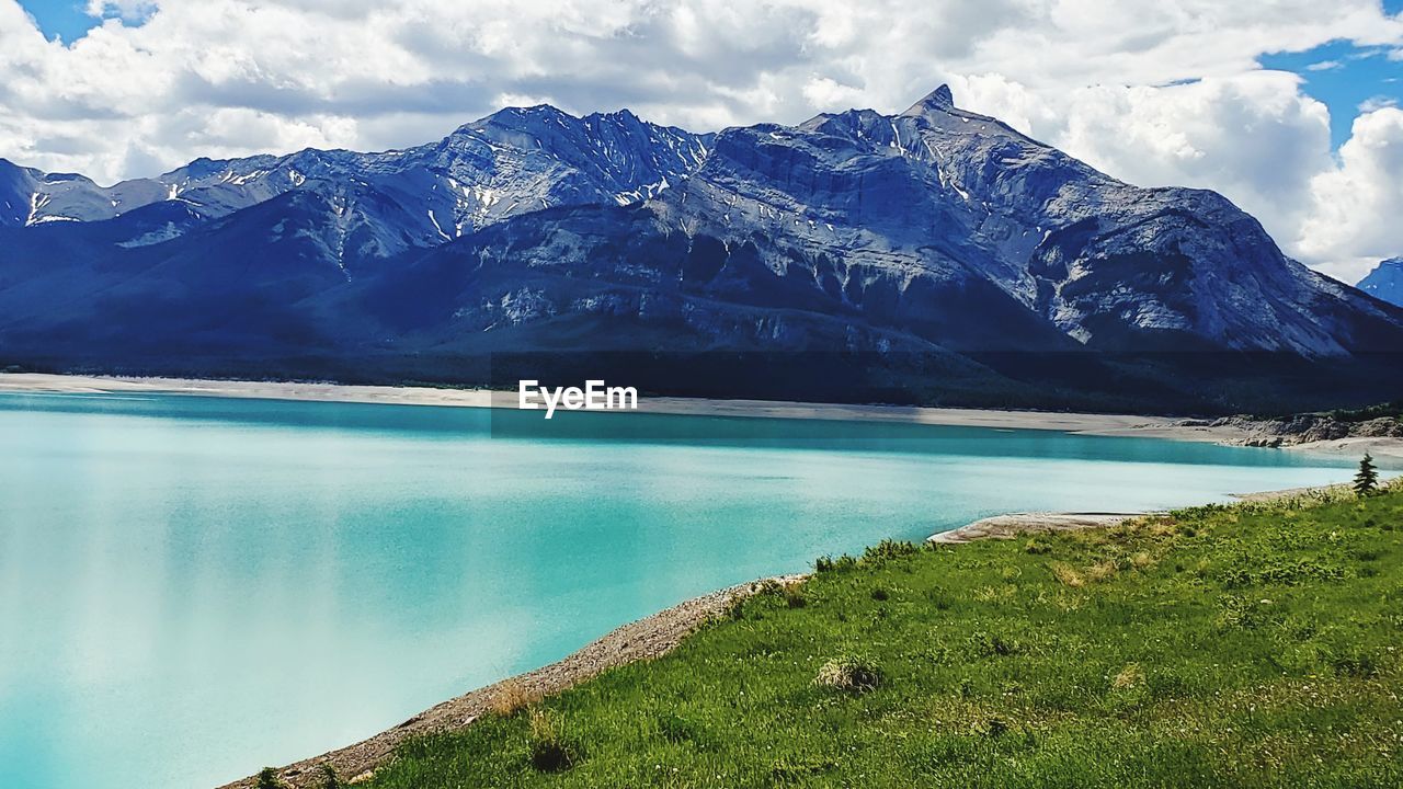 Scenic view of lake by mountains against sky