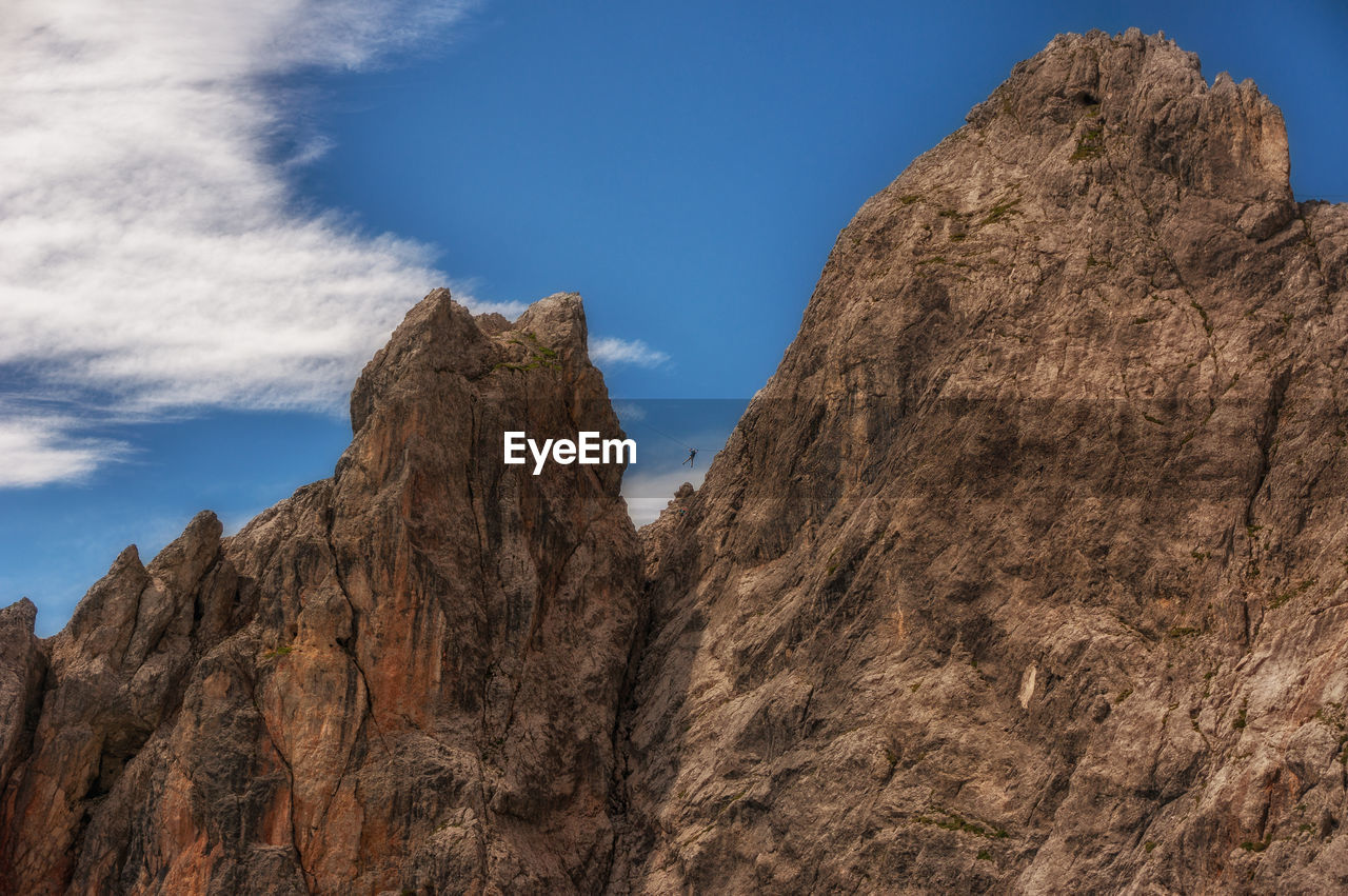 LOW ANGLE VIEW OF ROCK FORMATION IN MOUNTAINS AGAINST SKY