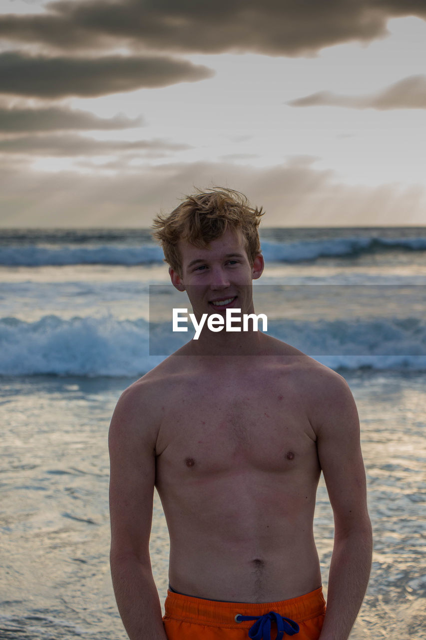 Portrait of shirtless young man at beach
