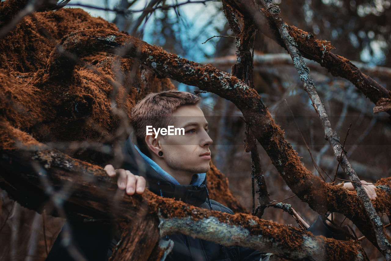 Mid adult man looking away in forest