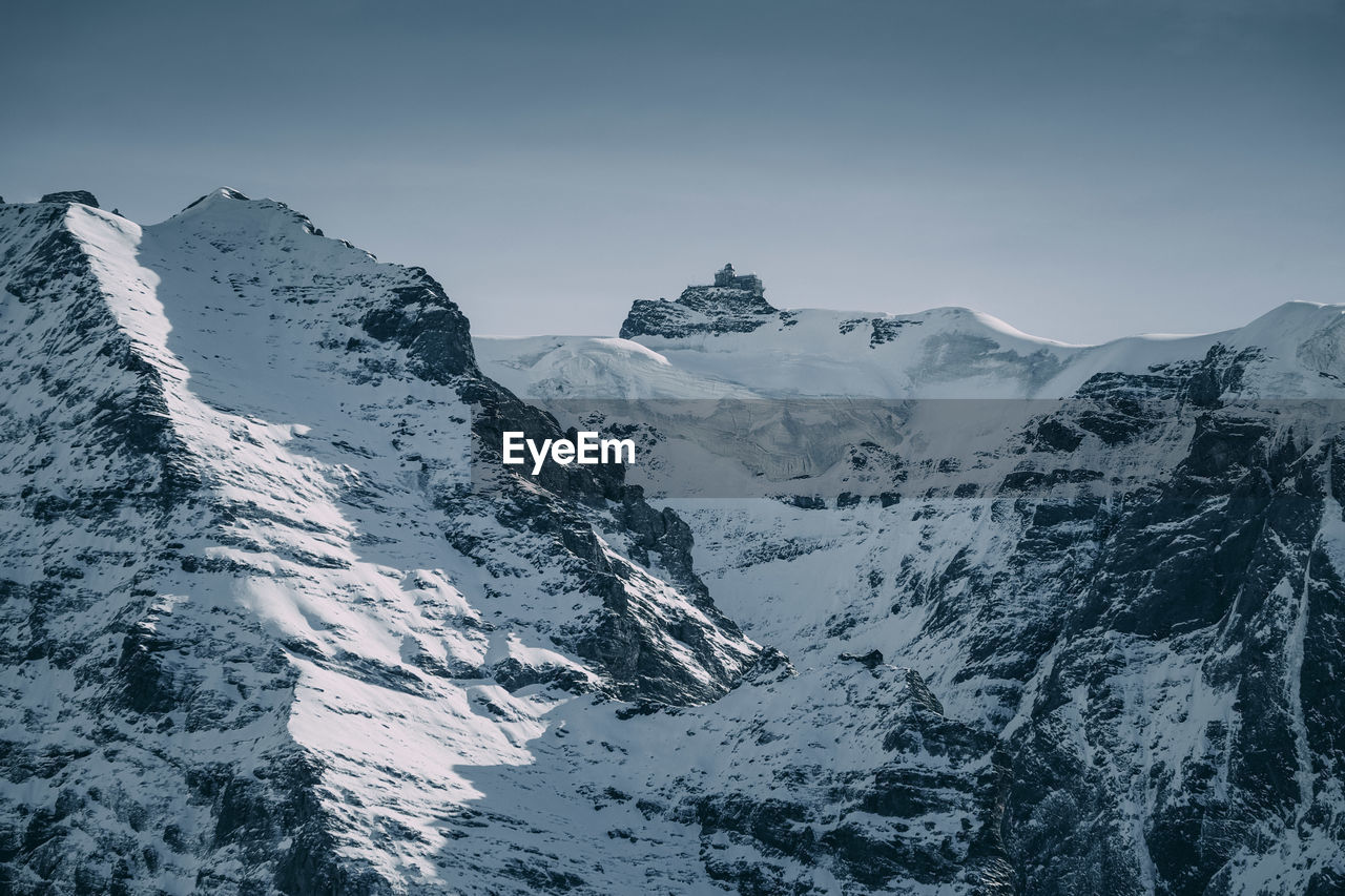 Scenic view of snowcapped mountains against clear sky