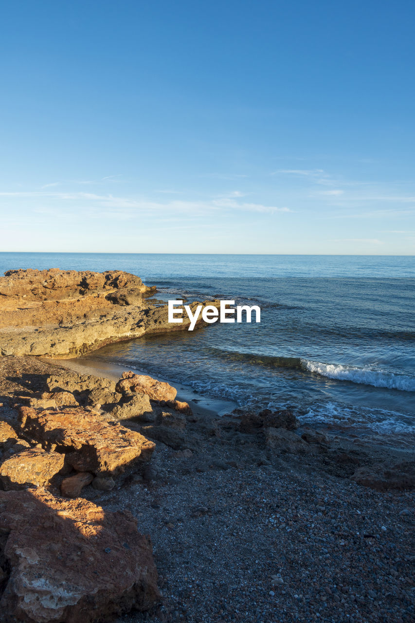 Scenic view of beach against blue sky