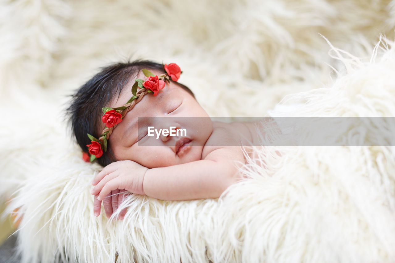 Close-up of cute baby girl sleeping on rug at home